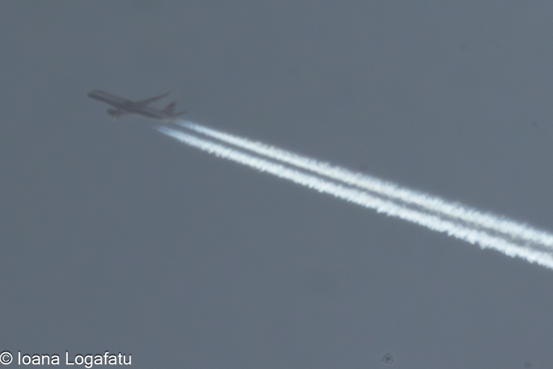 Plane flies through clouds, leaving trails